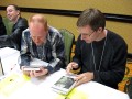 Karl Schroeder prepares to sign his Virga Books while Matt Jarpe admiires the Stephan Martineire cover art