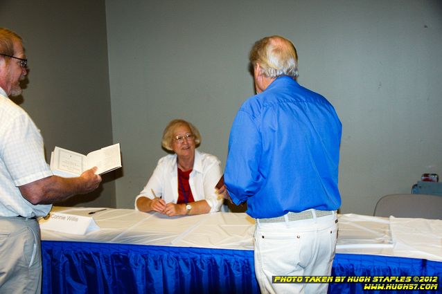 Connie Willis signs books for her fans, as Robert Silverberg drops by to say hi.