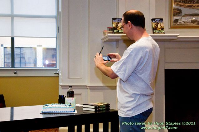 John Scalzi signs Fuzzy Nation\nA rather meta picture of a man taking a picture of his birthday cake. (Happy 42, John!)