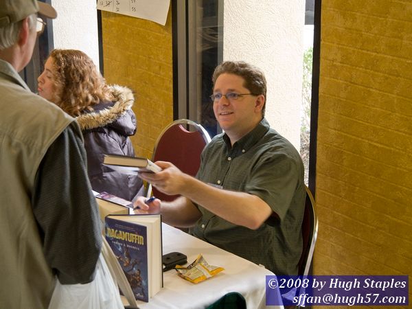 Author Tobias Buckell autographs his books