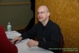 Guest of Honor Robert J. Sawyer signs books at the Autograph Table