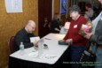 Guest of Honor Robert J. Sawyer signs books at the Autograph Table