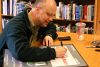 Rob signs in-store poster for the store manager