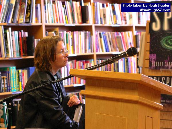Carolyn Clink, wife of Rob Sawyer, helps set up podium before event.